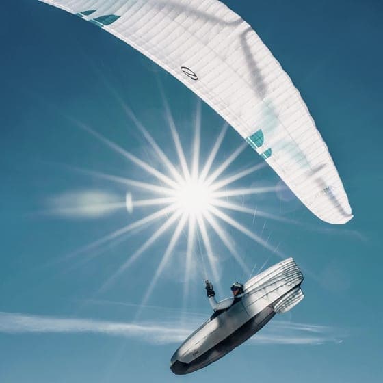 Gleitschirm im Gegenlicht, die Sonne als Stern hinter der Kappe